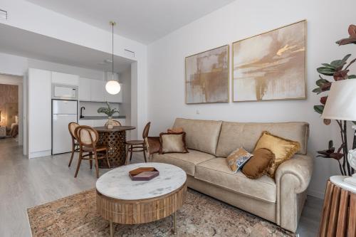 格拉纳达Apartamentos Puerta Elvira Suites 3000的带沙发和桌子的客厅