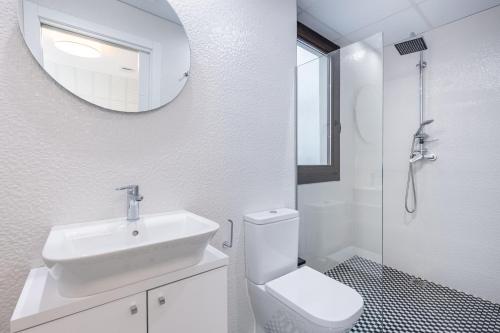 uma casa de banho com um lavatório, um WC e um espelho. em Apartamentos Albaicín Centro Suites 3000 em Granada