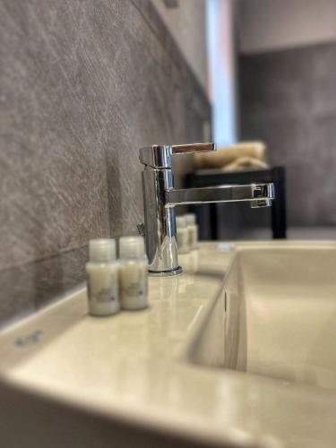 a bathroom sink with a faucet and three candles at Cà di Gat in La Morra