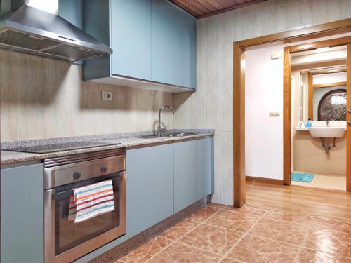 a kitchen with blue cabinets and a sink at Casa d´Amado in Sanxenxo