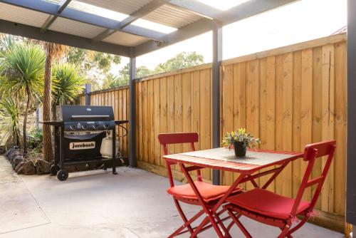 a patio with a table and chairs and a grill at Golfside Getaway in Rosebud