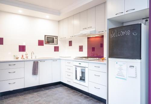 a kitchen with white cabinets and a chalkboard on the wall at Golfside Getaway in Rosebud