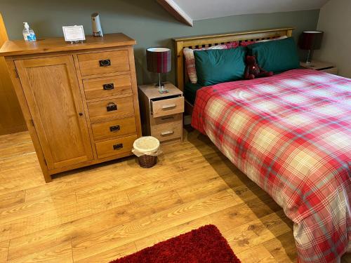 Un dormitorio con una cama y una cómoda de madera. en Inviting 1-Bed Studio in Pitlochry, en Pitlochry