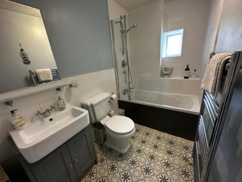 a bathroom with a sink and a toilet and a tub at Kirkmay House in Crail