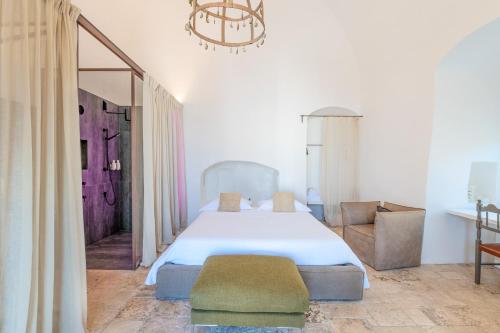 a bedroom with a large bed and a chandelier at Arya Nobile Dimora in Carovigno