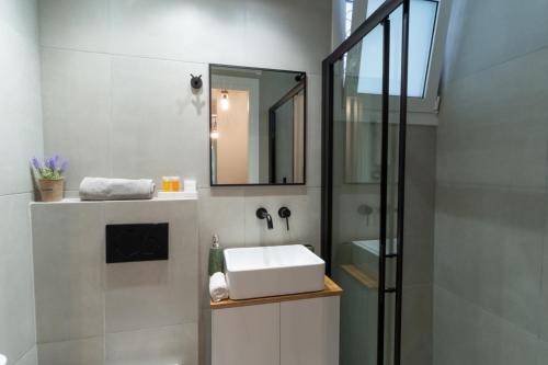 a bathroom with a sink and a mirror at Aiolos kolonaki vip apartment in Athens