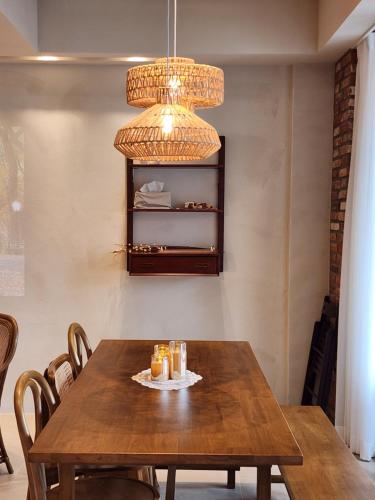 a dining room with a wooden table and a chandelier at Poolvilla Gaon in Busan