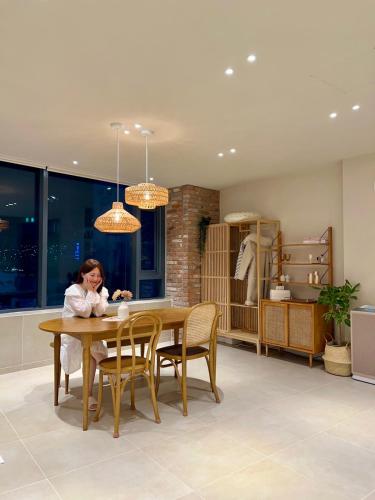 a woman sitting at a table in a kitchen at Poolvilla Gaon in Busan