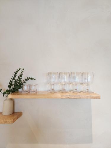 a row of wine glasses sitting on a wooden shelf at Poolvilla Gaon in Busan