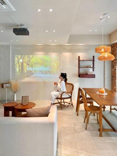 a woman sitting in a chair in a living room at Poolvilla Gaon in Busan