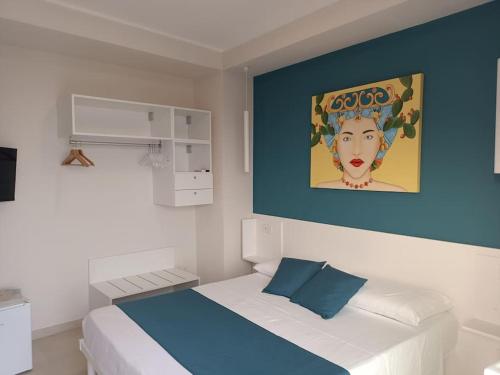 a bedroom with a bed with a painting on the wall at Stanza Mylai Etna View in Castelmola