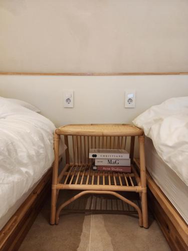 a small wooden bench sitting between two beds at Poolvilla Gaon in Busan