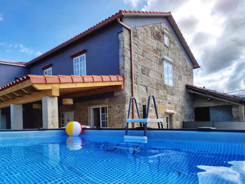 a swimming pool in front of a house at Casa d´Amado in Sanxenxo