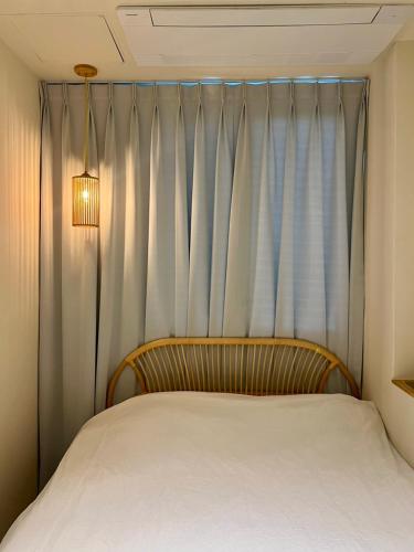 a bedroom with a bed and a curtain at Poolvilla Gaon in Busan