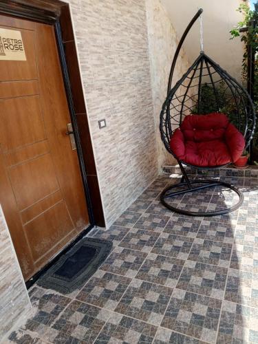 a swing with red pillows sitting next to a door at Petra Rose Apartment in Wadi Musa