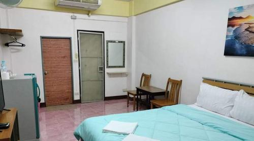 a bedroom with a bed and a table and a desk at DD Mansion in Ban Talat Rangsit