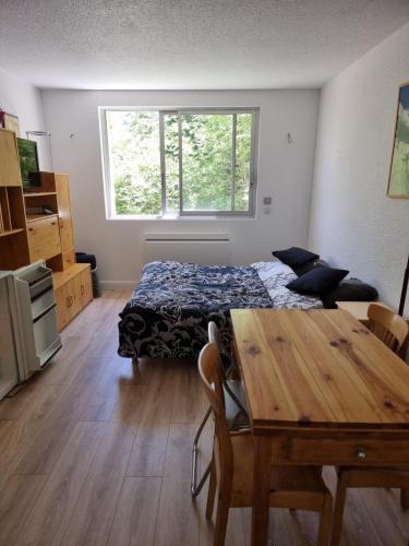 une chambre avec un lit, une table et une fenêtre dans l'établissement Studio La Grande Chaume A, à Enchastrayes