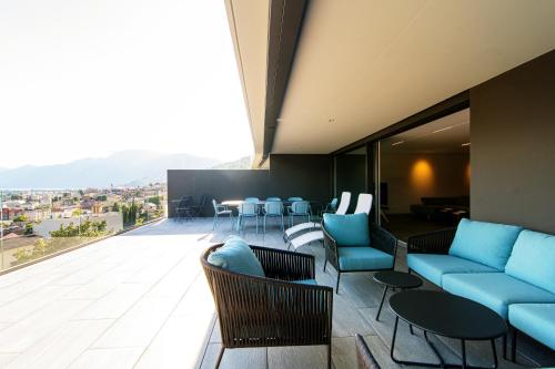 um quarto com sofás e cadeiras azuis numa varanda em Panoramic Minusio by Quokka 360 - Luxury with Lake View em Minusio