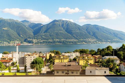 a view of a town with mountains in the background at Panoramic Minusio by Quokka 360 - Luxury with Lake View in Minusio