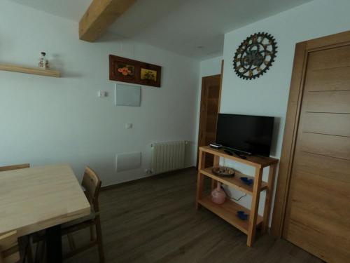 een woonkamer met een tafel en een tv en een eetkamer bij Apartamentos Sierra y Mar Aldealengua de Pedraza in Ceguilla