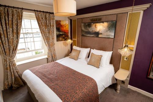 ヤーテにあるCross Hands Hotel by Greene King Innsの大きなベッドと窓が備わるホテルルームです。