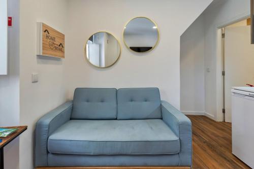 a blue couch in a living room with a mirror at Bonneville Setúbal I, By Home Match in Setúbal