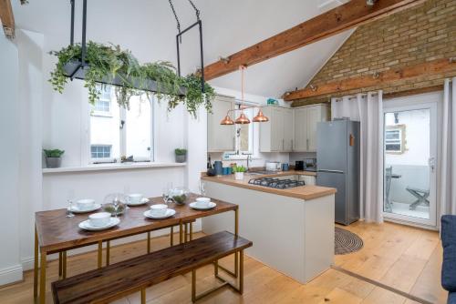 cocina con mesa y cocina con nevera en Stunning 3 Bedroom Duplex with Terrace en Brighton & Hove