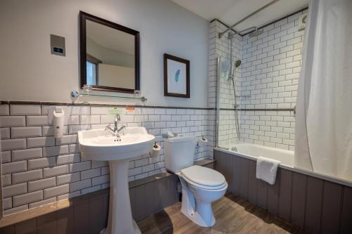 ein Badezimmer mit einem WC, einem Waschbecken und einer Badewanne in der Unterkunft Cross Hands Hotel by Greene King Inns in Yate