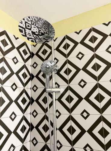 a shower in a bathroom with black and white tiles at ATHENS STORIES in Athens