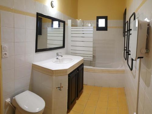 une salle de bain avec un lavabo, des toilettes et une baignoire dans l'établissement La Maison d'Isidore - Gîte 6 personnes avec climatisation, piscine et jardin clos, à Saint-Victor-la-Coste