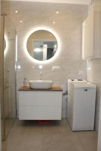 La salle de bains est pourvue d'un lavabo et d'un miroir. dans l'établissement Baltea Apartament Gdańsk Przymorze, à Gdańsk