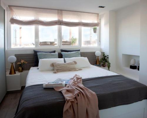 a bedroom with a large bed with a window at Ático con espectacular terraza en Bernabéu in Madrid