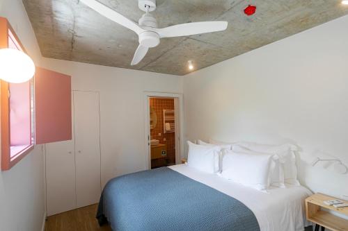 a bedroom with a bed with a ceiling fan at Solar Branco Eco Estate in Ponta Delgada