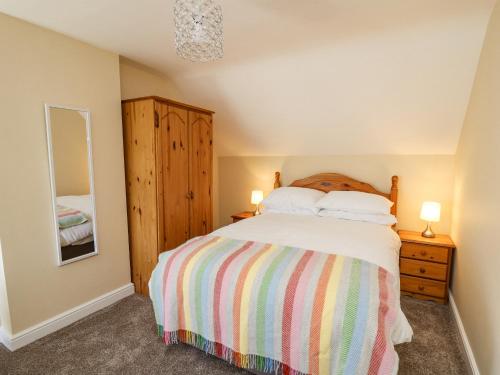 um quarto com uma cama, uma cómoda e um espelho em 2 Sunny Hill em Haverfordwest
