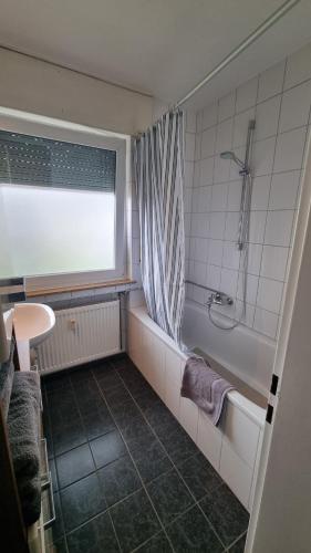 y baño con bañera, ducha y lavamanos. en Ferienwohnung Friedenau, en Steinfurt