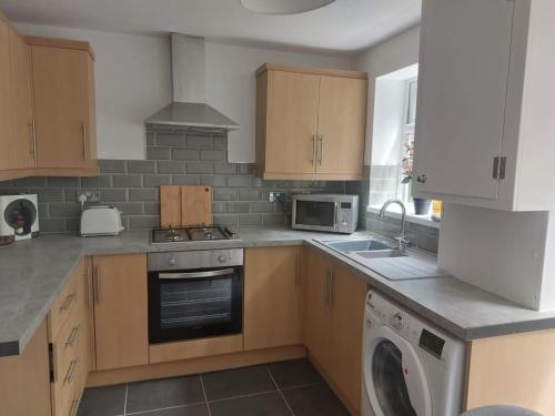 a kitchen with a stove and a dishwasher at Charming 2 BedRoom Tredegar Gem. Sleeps 4 in Tredegar