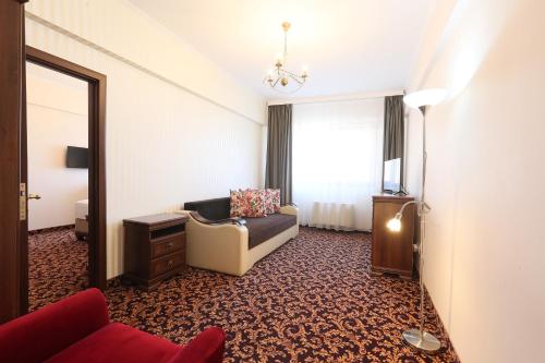 a living room with a couch and a window at Hotel Impero in Oradea