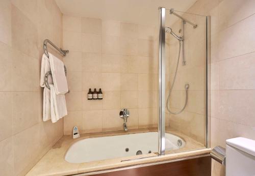 a bathroom with a shower and a bath tub at NH Collection A Coruña Finisterre in A Coruña