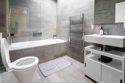 Immaculate 1-Bed House in London في لندن: حمام مع مرحاض وحوض استحمام ومغسلة