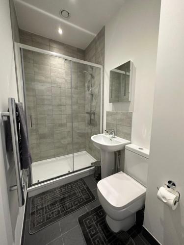 y baño con aseo, lavabo y ducha. en Sleek & Stylish Apartment by DH ApartHotels en Peterborough