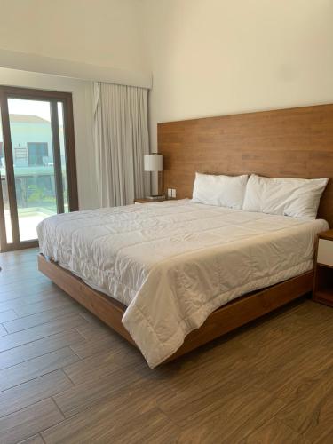 a bedroom with a large bed with a wooden headboard at Villas La Mar in Monterrico