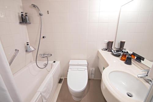 a bathroom with a toilet and a sink and a shower at Hotel Ninja Black in Kyoto