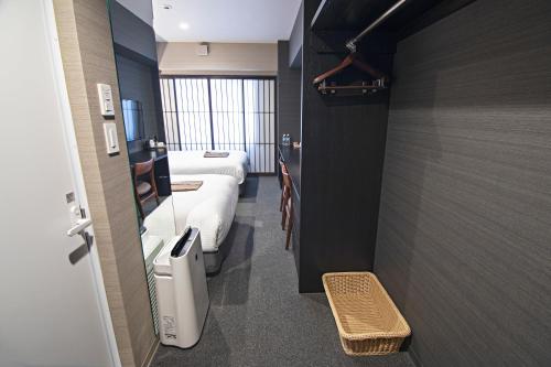 a hotel room with two beds and a hallway at Hotel Ninja Black in Kyoto