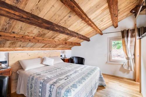 a bedroom with a bed and a wooden ceiling at b&b casa largo la piazzola in Vittorio Veneto
