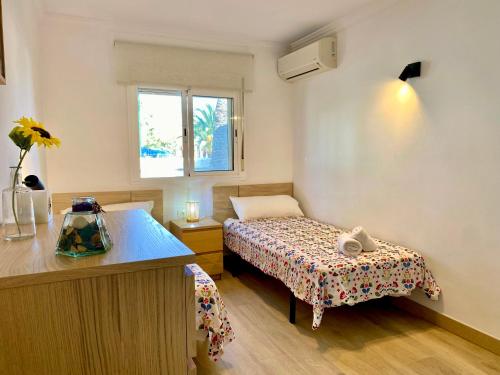 a small bedroom with a bed and a window at On the Beach Holiday Home in Los Cristianos