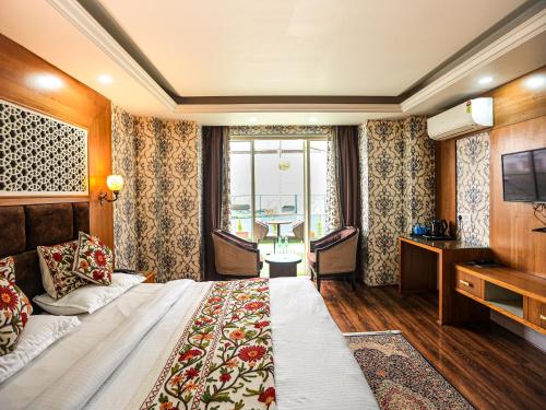 a hotel room with a large bed and a television at The Montreal Srinagar A Unit Of Montreal Group in Srinagar