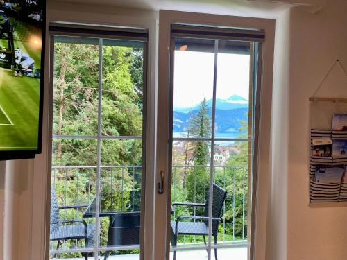 uma porta de vidro deslizante com vista para uma montanha em Beautiful flat with nice lake and mountain views em Weggis