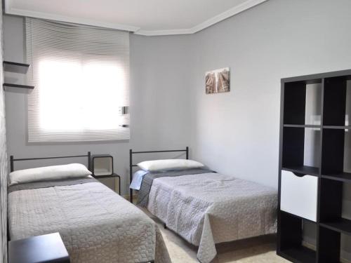ein Schlafzimmer mit zwei Betten und einem Fenster in der Unterkunft Acogedor apartamento en Burriana centro in Burriana
