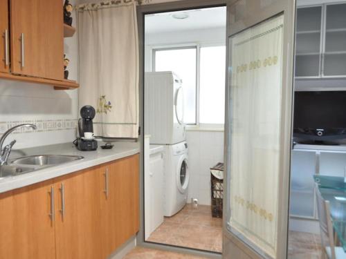 eine Küche mit Spüle, Waschmaschine und Trockner in der Unterkunft Acogedor apartamento en Burriana centro in Burriana