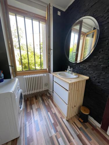 een badkamer met een wastafel en een spiegel bij Chambre d’hôte proche gare et centre 1 in Besançon